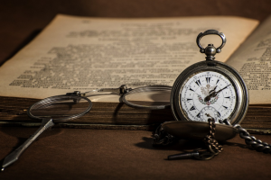 pixabay- książka, lupa, zegarek kieszonkowy na stole 